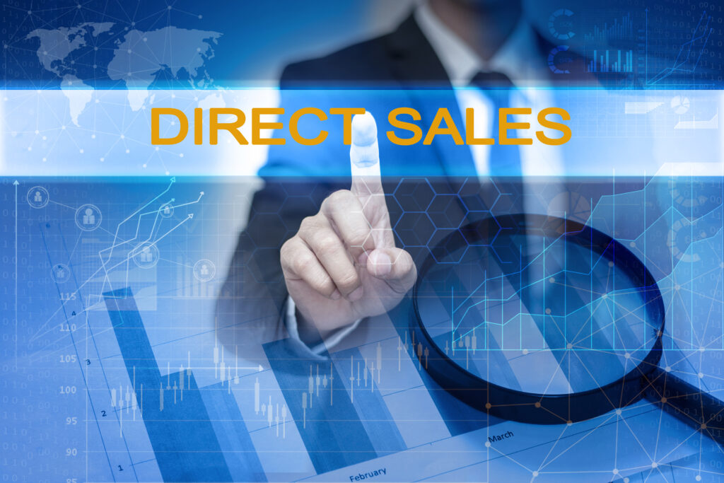 A businessman's hand touching the word "direct sales"